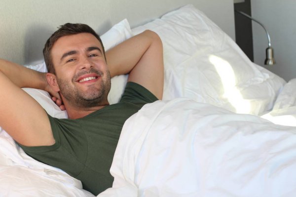Man Happily Relaxing in Bed