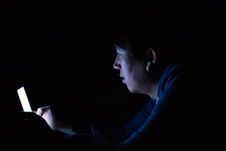 Person using their phone in the dark