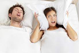 Man snoring while asleep and keeping his partner awake